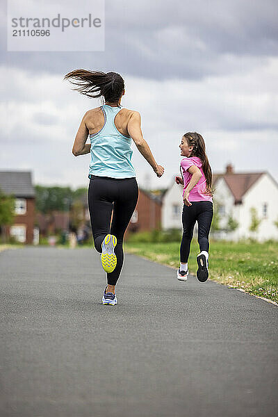 Mother running with daughter on road