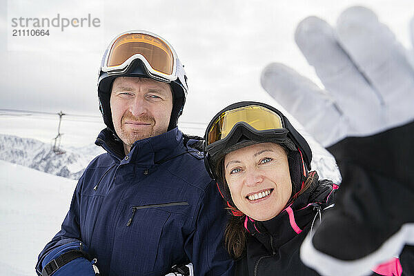 Happy man and woman enjoying ski holiday in winter