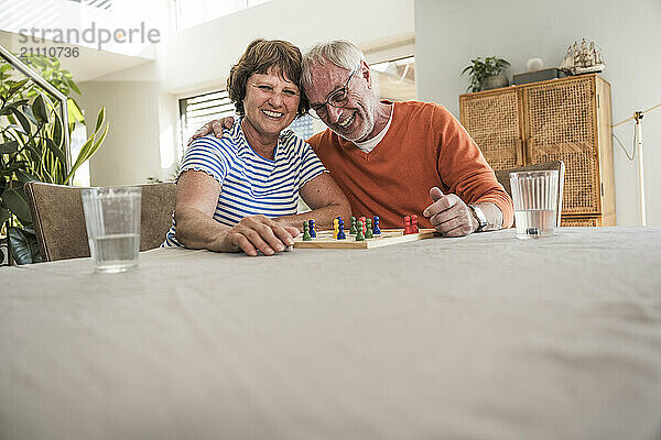 Senior couple playing board game at home