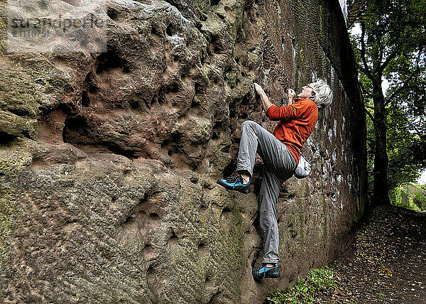 Mature climber climbing Pex Hill in England