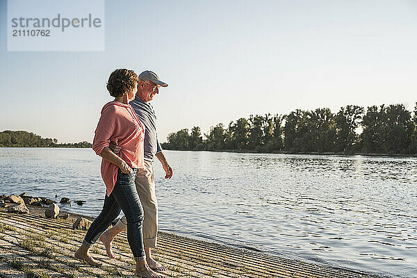 Senior couple enjoying near river on sunny day