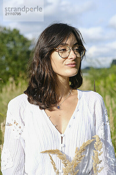 Young woman wearing eyeglasses in meadow