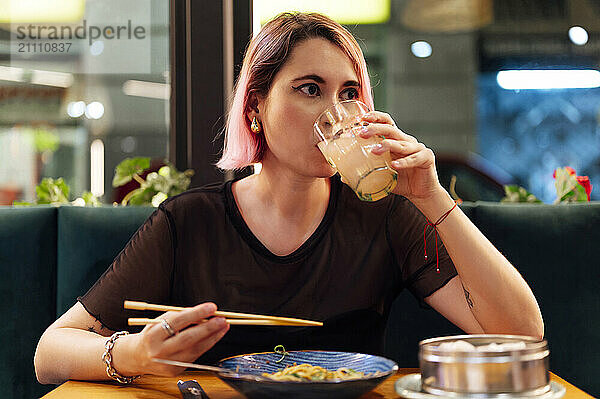 Hipster woman drinking juice in restaurant