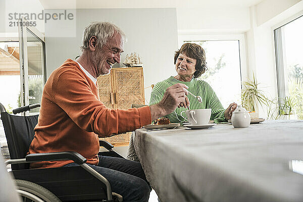 Senior couple enjoying coffee and cake at home