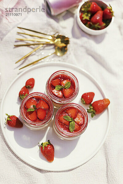 Panna cotta with strawberries in jars kept in plate