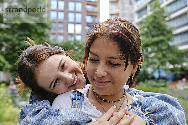 Affectionate woman embracing girlfriend at paark