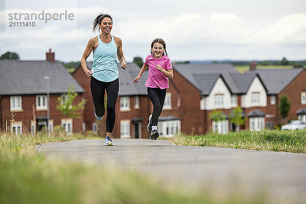 Woman running next to daughter on road