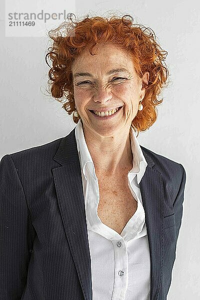 Cheerful redhead businesswoman against white background