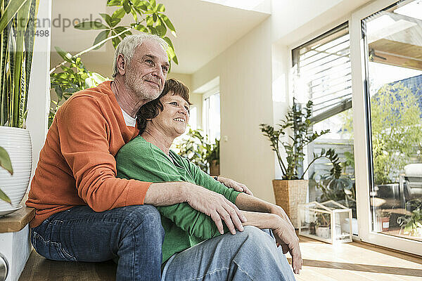 Affectionate senior couple sitting at doorstep