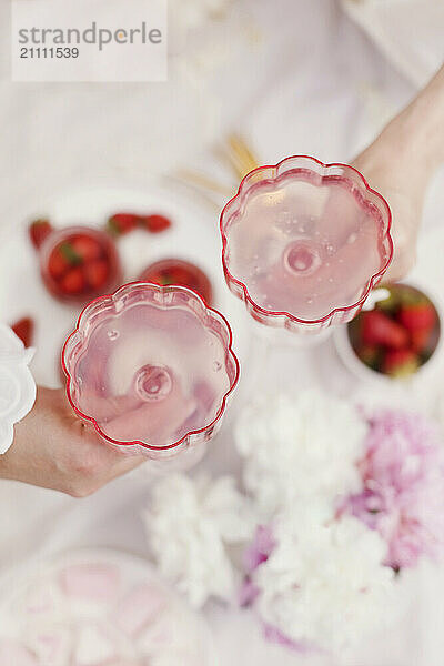 Friends doing celebratory toast with pink lemonade