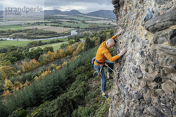 Rock climber climbing Moy Rock in Scotland