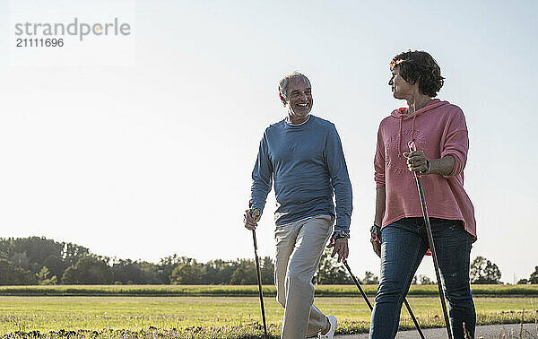 Happy man with woman walking near meadow