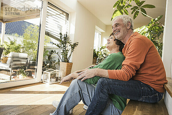 Smiling senior couple sitting together at doorstep