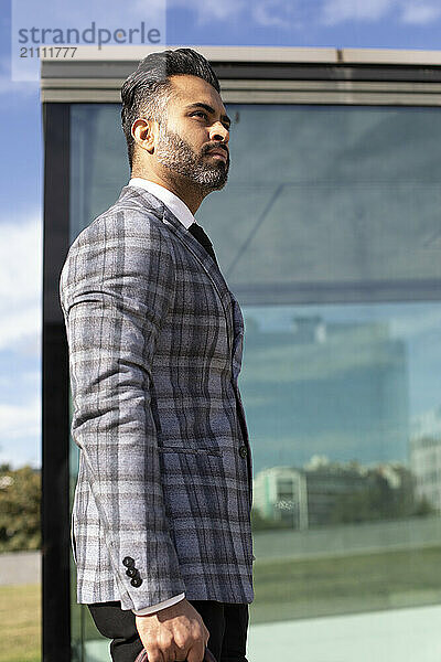 Businessman in suit standing outside glass building