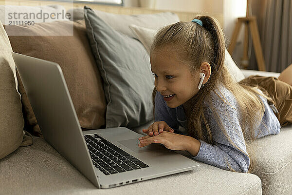 Girl scrolling on laptop at home