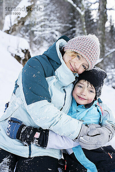 Smiling mother embracing son at winter