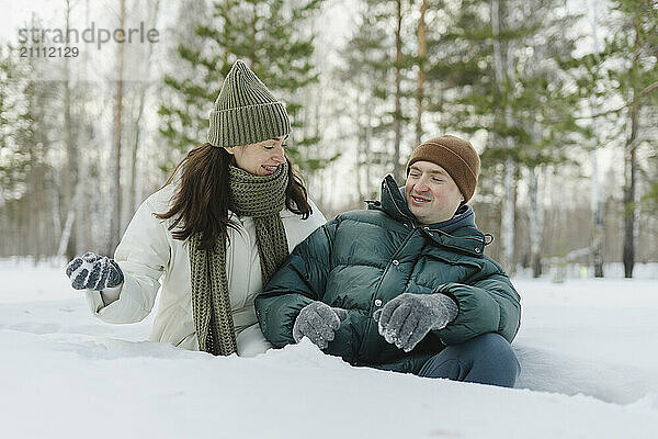 Playful couple playing with snow in winter