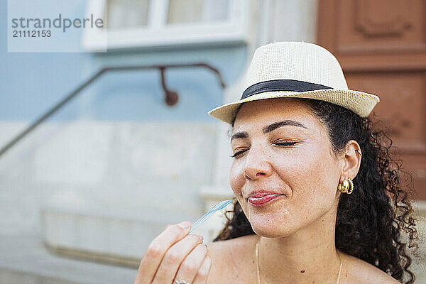 Woman wearing hat eating ice cream