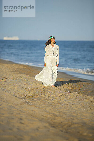 Young woman walking on wet sand at beach