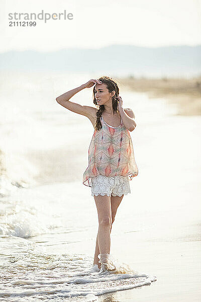 Woman shielding eyes at beach