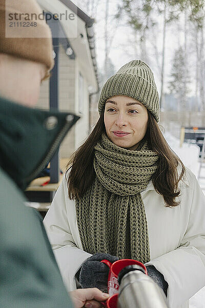 Woman in warm clothes holding coffee cup