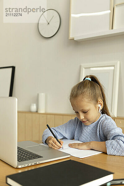 Girl studying in front of laptop at home