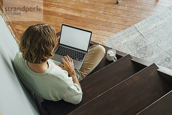 Young man working on laptop at home