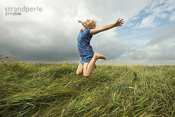 Joyful girl jumping in agricultural field