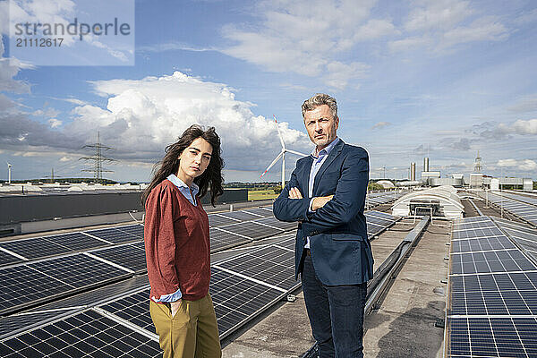 Business colleagues standing near solar panels on rooftop