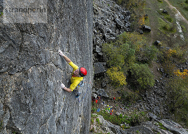 Mature rock climber climbing rock