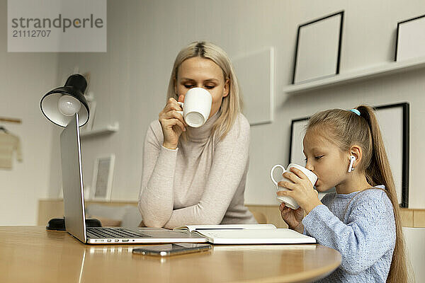 Mother and daughter drinking tea at home