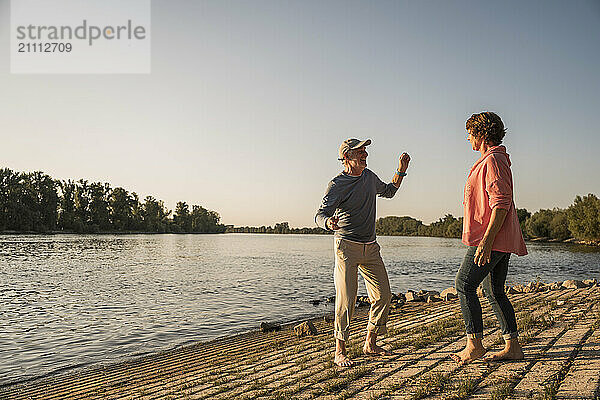 Happy senior couple dancing and enjoying at riverbank