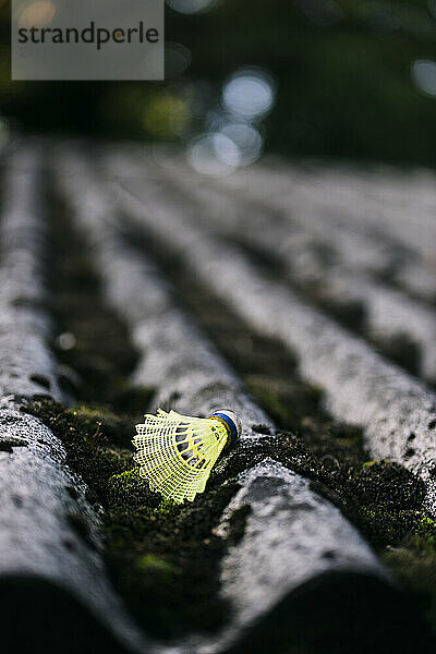 Yellow shuttlecock on corrugated rooftop