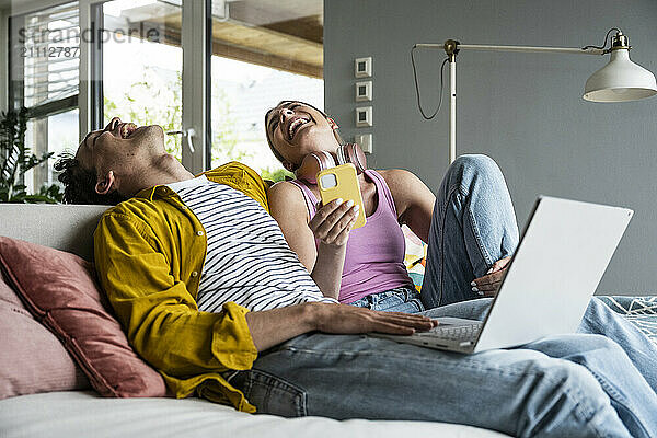 Cheerful young couple spending leisure time at home