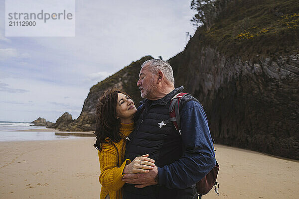 Senior man dancing with woman at beach