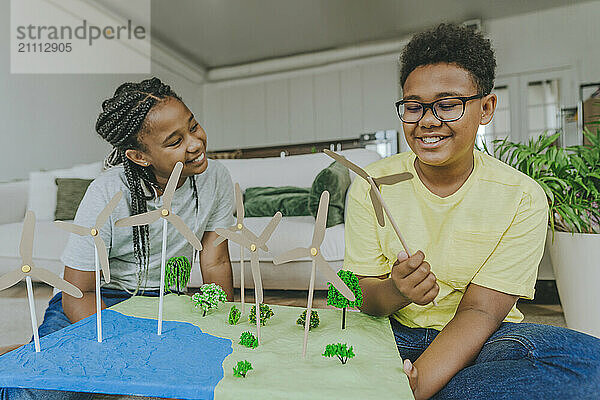 Happy siblings preparing solar energy project at home