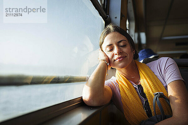 Woman relaxing on train window sill