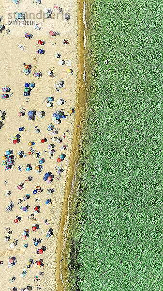 Drone view of beach with colorful umbrellas