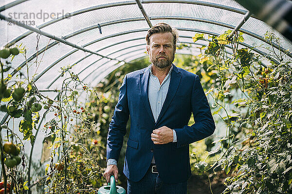 Businessman wearing blazer and standing in vegetable garden