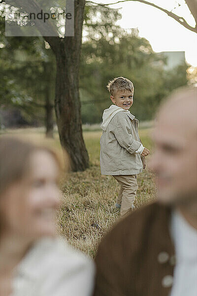 Cute boy looking at parents in park