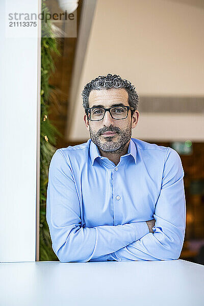 Contemplative businessman wearing eyeglasses at co working space