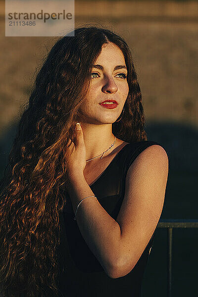 Young woman with long hair in black dress