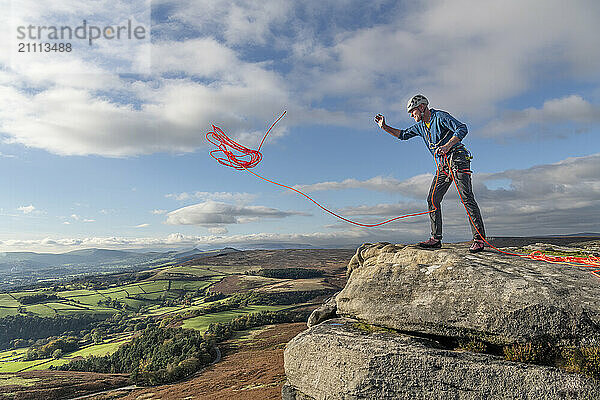 Man throwing rope from Stanage Edge in England