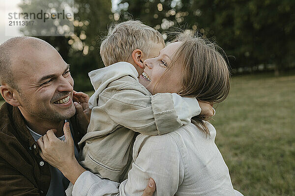 Son embracing mother at park