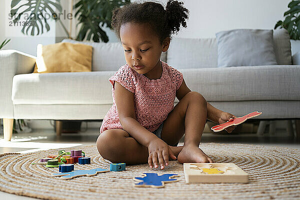 Girl playing with puzzles at home