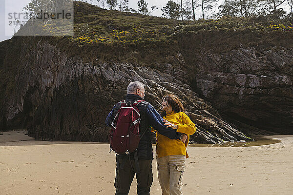 Carefree elderly couple dancing at beach