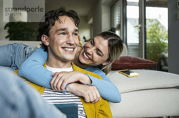 Happy woman embracing boyfriend at home