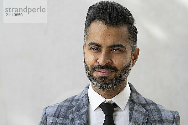 Smiling businessman in front of white background