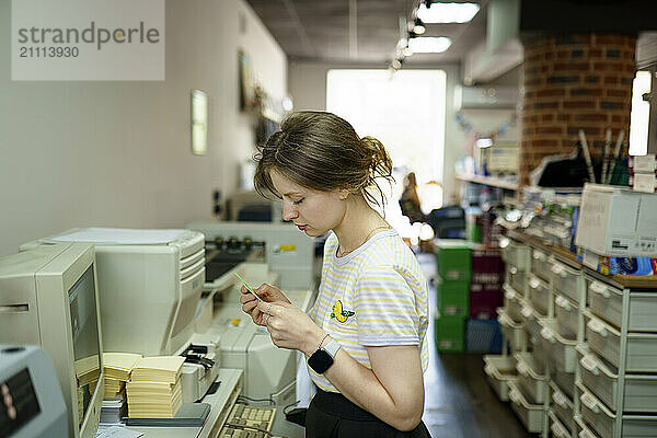 Woman standing near computer in a printing shop