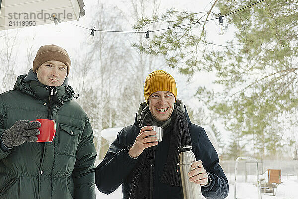 Happy friends enjoying hot coffee in winter